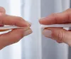 Two hands holding pieces of white foam tape. Náhľad obrázku produktu