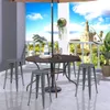 A patio set with four bar stools and a round table on a balcony overlooking a cityscape and river. Náhľad obrázku produktu