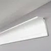 A close-up shot of white crown molding installed at the junction of a wall and ceiling. Produktbild-Vorschau