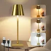 A collage of images showing a gold table lamp with USB charging cables and a small decorative figure. Anteprima dell’immagine prodotto