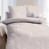 A neatly made bed with beige bedding featuring a white leaf pattern, set against a bright, slightly blurred background. Produktbild-Vorschau