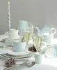 A table setting with a candle, tea set, and glasses of champagne, suggesting a festive or celebratory occasion. Voir les images du produit