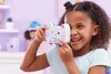 A young girl is holding a toy camera shaped like a cat and looking through the viewfinder. Produktbild-Vorschau