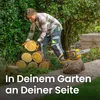 A woman is stacking logs in a garden with a chainsaw nearby. Produktbild-Vorschau