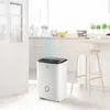 A white dehumidifier is shown in a bright, modern kitchen setting. Produktbild-Vorschau