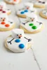 A close-up shot of several snowman-shaped cookies decorated with white icing and colorful candies. Produktbild-Vorschau