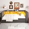 A gray daybed with built-in shelving and LED lighting, made up with white bedding and a throw blanket, is shown in a room setting with artwork on the wall. Náhled obrázku produktu