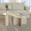 A living room scene with a sofa and two round coffee tables made of travertine. Produktbild-Vorschau