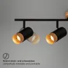 A close-up view of a black spotlight with a wooden interior, mounted on a black track. Produktbild-Vorschau