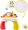 A colorful interactive musical table for babies and toddlers, with various toys and features, including a bunny and a train. Produktbild-Vorschau