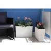 A balcony setting with a chair and two planters filled with flowers. Produktbild-Vorschau