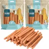 Two bags of dog treats and a pile of dog treats in front of them. Produktbild-Vorschau