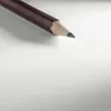 A close-up of a sharpened pencil on a white surface. Anteprima dell’immagine prodotto