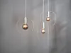 Three modern pendant lights with exposed Edison-style bulbs hang against a gray wall. Podgląd zdjęcia produktu