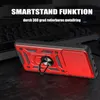 A red and black phone case with a ring holder is displayed on a dark surface, with a blurred keyboard in the background. Produktbild-Vorschau