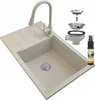 A beige granite kitchen sink with a pull-out faucet and accessories, including a drain assembly and a cleaning spray bottle. Podgląd zdjęcia produktu
