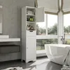 A modern bathroom with a white freestanding bathtub, a tall white storage cabinet, and large windows overlooking a green landscape. Produktbild-Vorschau