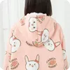 Close-up of the back of a person wearing a pink hoodie blanket with a rabbit and carrot pattern. Náhled obrázku produktu