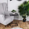A side table with a plant sits next to a chair in a living room. Podgląd zdjęcia produktu