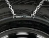 A close-up view of a tire chain attached to a tire. Produktbild-Vorschau