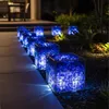 Beleuchtete Gabionenkörbe gefüllt mit blauen Glasbrocken entlang eines Gartenwegs Produktbild-Vorschau
