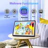 A digital photo frame displaying children playing is placed on a small wooden table next to a couch with striped pillows. Produktbild-Vorschau