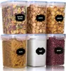 A set of six clear plastic food storage containers with blue lids, filled with various food items and labeled with black chalkboard-style labels. Produktbild-Vorschau