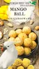 A white cockatoo is shown next to a bowl of mango balls and some loose mango balls on a burlap-like surface, with a mango in the background. Text overlays indicate it's premium parrot food. Voir les images du produit
