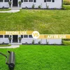 A split image showing a lawn before and after using a lawn aerator. The top half shows a patchy lawn in front of a house, labeled 'BEFORE USE'. The bottom half shows a lush, green lawn with a lawn aerator in the foreground, labeled 'AFTER USE'. Produktbild-Vorschau