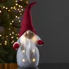 A festive gnome decoration with lights, placed in front of a blurred Christmas tree. Produktbild-Vorschau