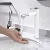 A person is washing their hands under a modern white and silver faucet in a bathroom sink. Produktbild-Vorschau