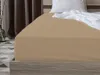 A close-up view of a beige fitted sheet on a bed. Produktbild-Vorschau