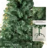 A close-up view of a green artificial Christmas tree with some lights and text overlays highlighting its features. Produktbild-Vorschau