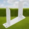 A white metal U-shaped post bracket is shown outdoors against a blurred background of green grass and a blue sky. Podgląd zdjęcia produktu