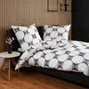 A bed with geometric patterned bedding in a bedroom with a slatted wooden wall. Produktbild-Vorschau