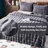 A close-up view of a fluffy gray blanket and pillows on a bed, with a circular inset showing a measurement of 4cm and text describing the product's texture. Náhled obrázku produktu