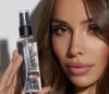 A woman is holding a bottle of Byrokko Tanning Mist in front of her face. Produktbild-Vorschau