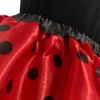 Close-up of a red and black polka dot fabric, likely part of a costume or skirt. Produktbild-Vorschau