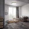 A living room scene with a sofa, coffee table, rug, and a large window with a view of trees. Podgląd zdjęcia produktu