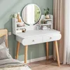 A white vanity table with a round mirror, set up in a bedroom next to a bed. Podgląd zdjęcia produktu