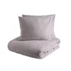 A beige duvet cover and two pillowcases are neatly folded and stacked on a white background. Produktbild-Vorschau