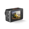 A black action camera with an orange accent is shown from a side-diagonal angle against a white background. The camera's screen displays a rider on a yellow motorcycle. Produktbild-Vorschau