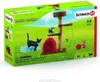 The image shows the packaging for a Schleich Farm World cat playset, featuring toy cats, a cat tree, and a cat house on a green grassy background. Náhľad obrázku produktu