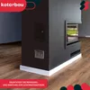 A modern black fireplace insert with a glass window, set against a dark wall and wooden floor. A red banner at the bottom contains text. Náhľad obrázku produktu