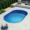An oval-shaped swimming pool filled with blue water, set in a tiled backyard with a wooden deck and some greenery. Produktbild-Vorschau