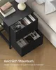 A black nightstand with two open drawers next to a bed. Produktbild-Vorschau
