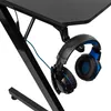 A close-up view of a black gaming desk with a pair of black and blue headphones hanging from a hook. Anteprima dell’immagine prodotto