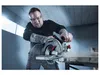 A man is using a circular saw to cut wood in a workshop. Produktbild-Vorschau