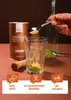 A hand is adding sugar from a spoon into a glass with lime and mint, next to a can of Xucker Bronxe sugar. Produktbild-Vorschau