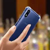 A hand holding a blue smartphone with a transparent protective case. Produktbild-Vorschau